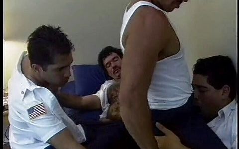 Hairy fireman sits back on a bed and enjoys gay orgy