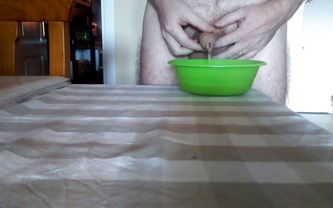 John is peeing into a green bowl on the table